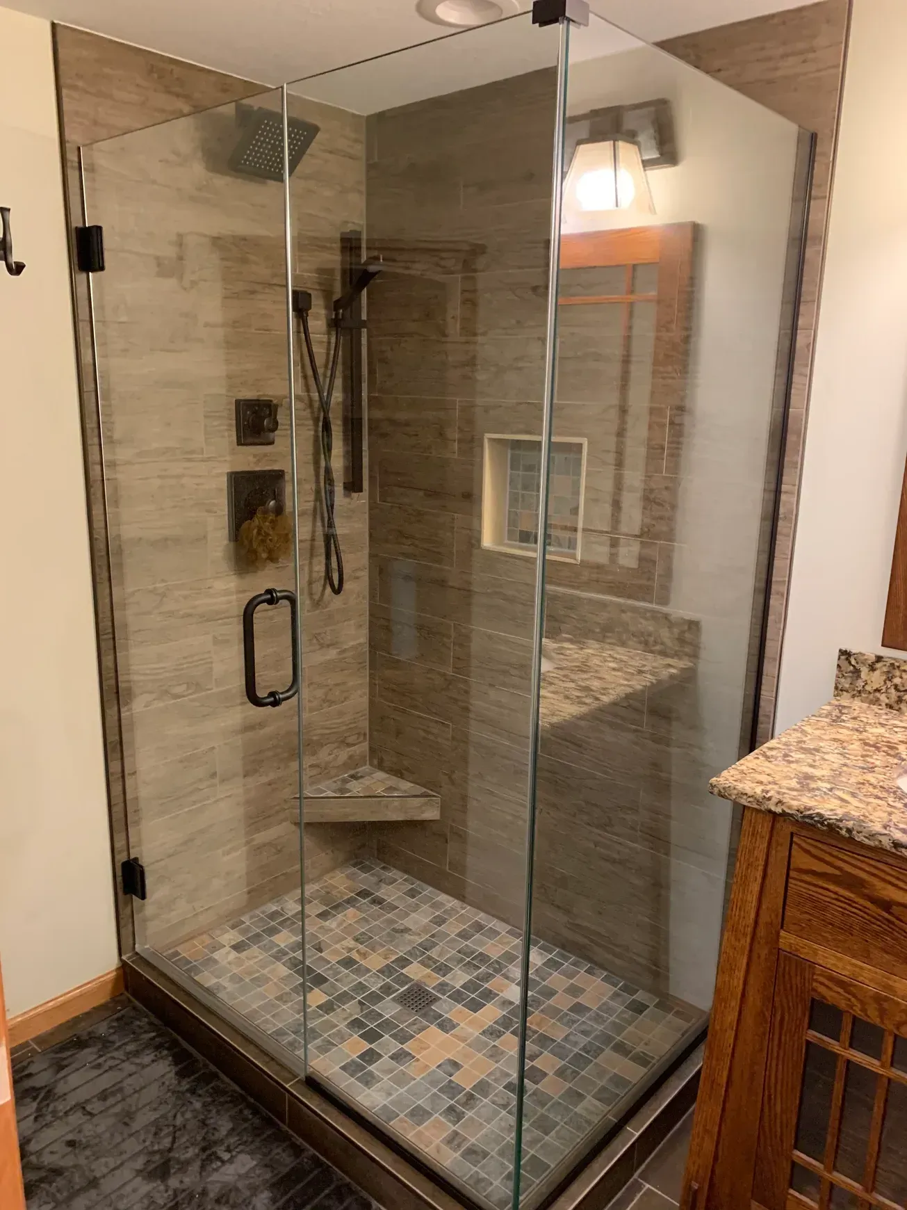 A bathroom with a walk in shower and a sink.