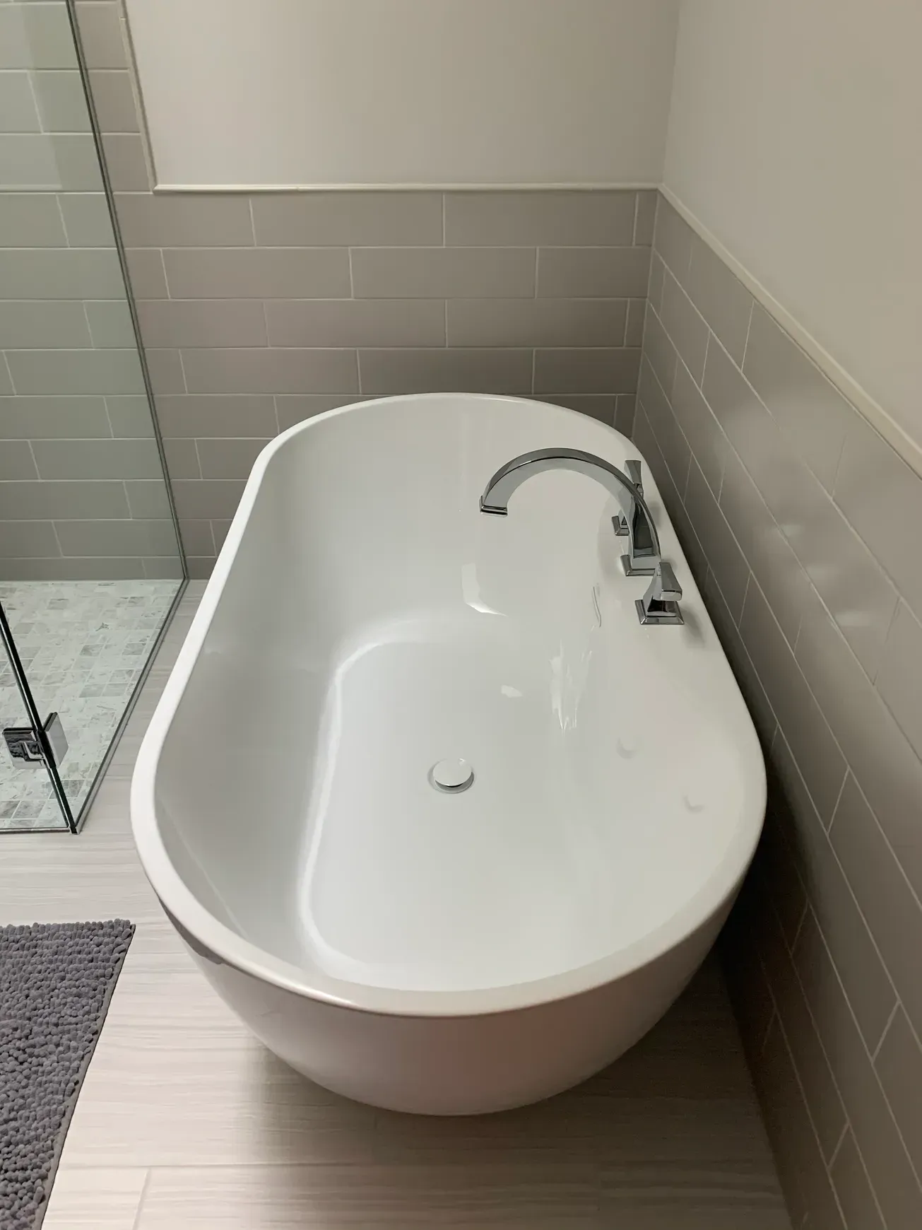 A white bathtub is sitting in a bathroom next to a shower.