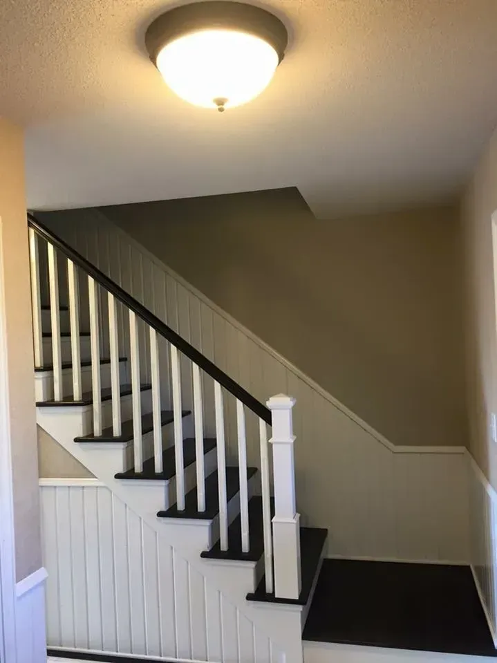 A staircase with white railings and black steps