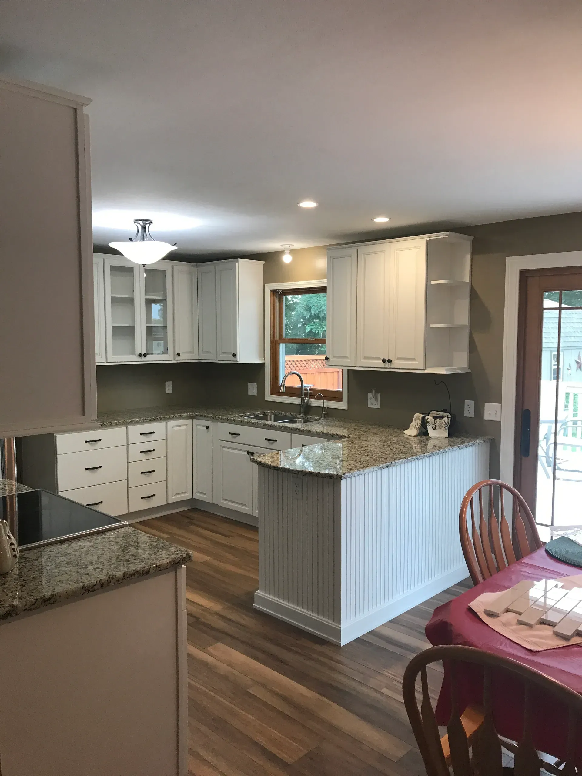 A kitchen with white cabinets and granite counter tops