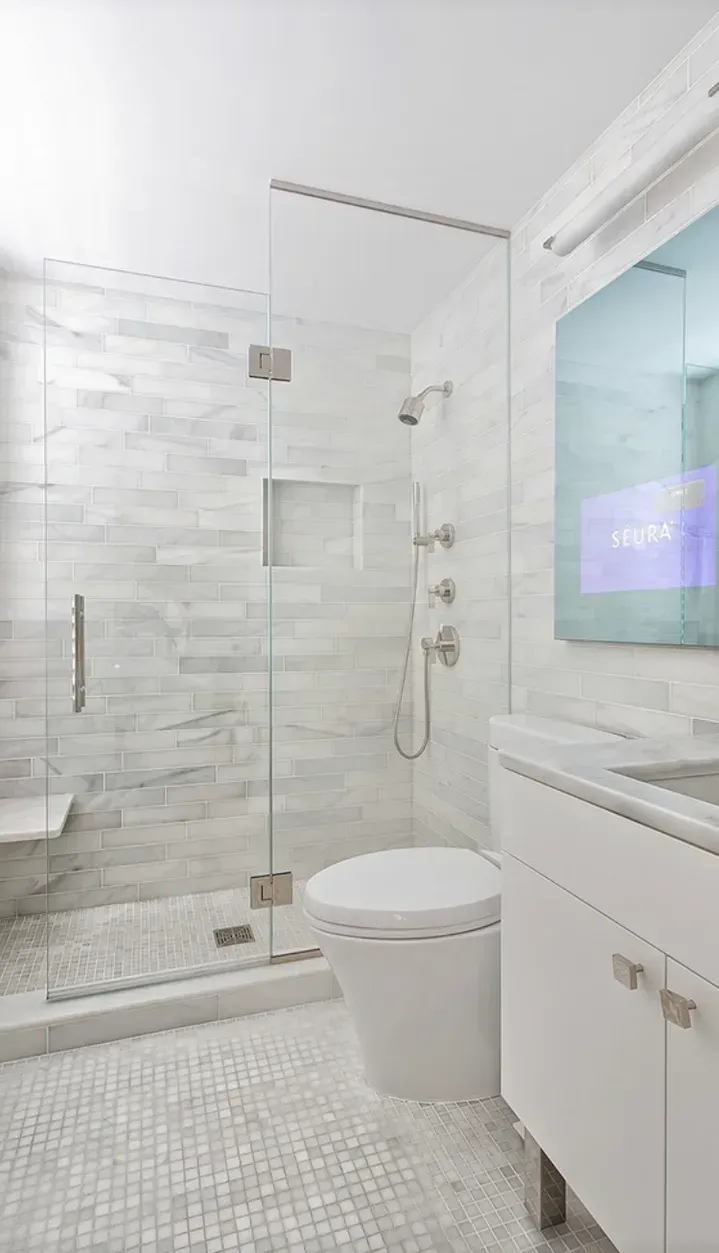 A bathroom with a toilet , sink , shower and mirror.