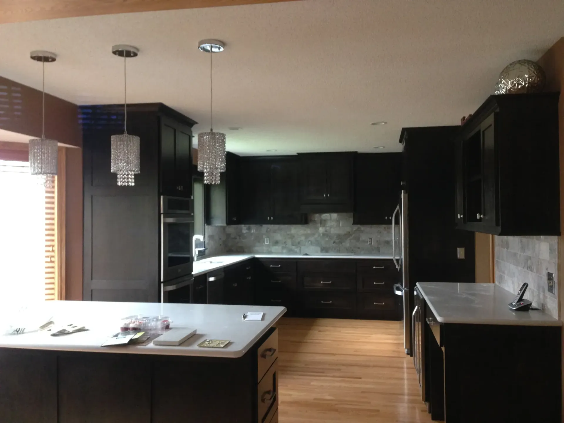 A kitchen with black cabinets and white counter tops
