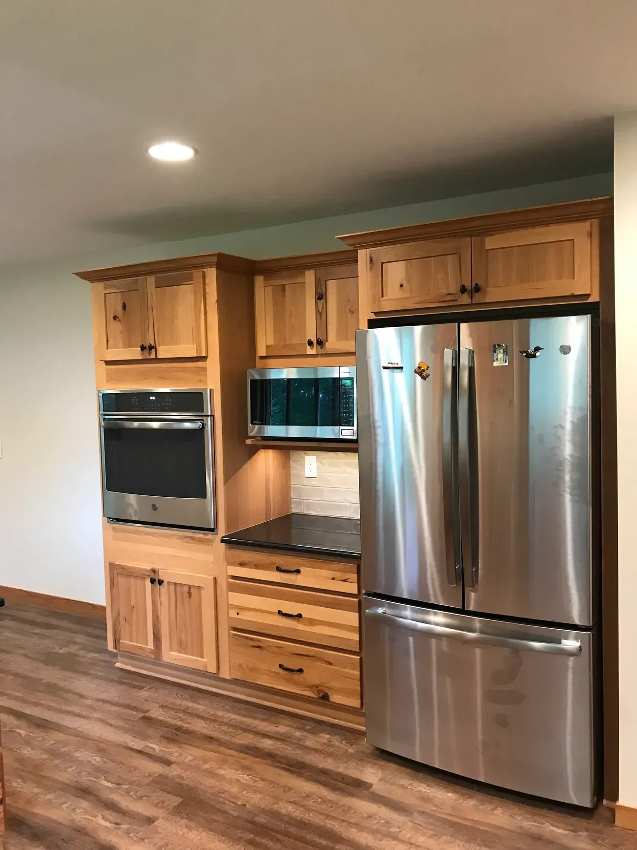 A kitchen with stainless steel appliances and wooden cabinets.