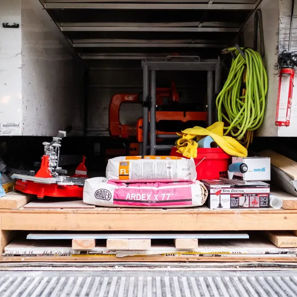 The back of a truck is filled with lots of tools and supplies.