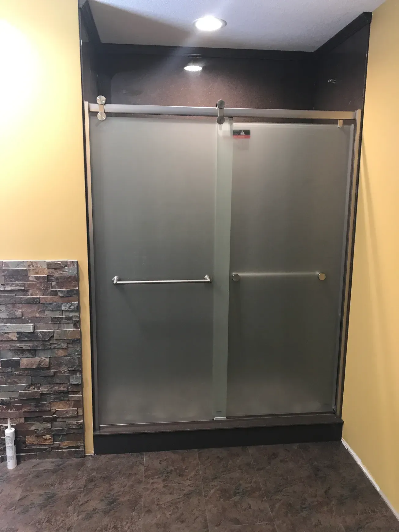 A bathroom with a sliding glass shower door