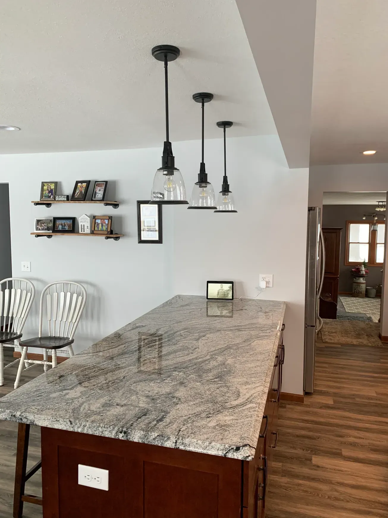 A kitchen with a large granite counter top and a wooden island.