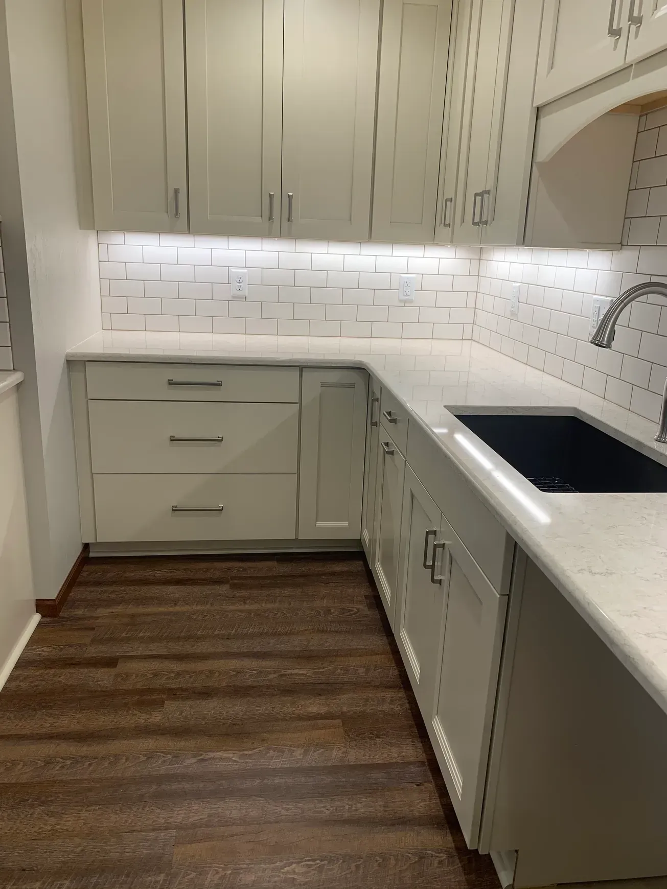 A kitchen with white cabinets and a sink.