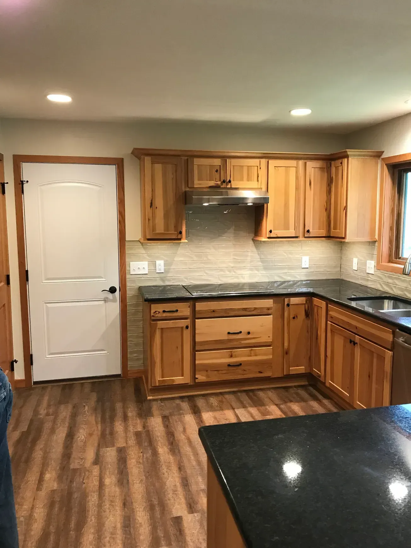 A kitchen with wooden cabinets and black counter tops