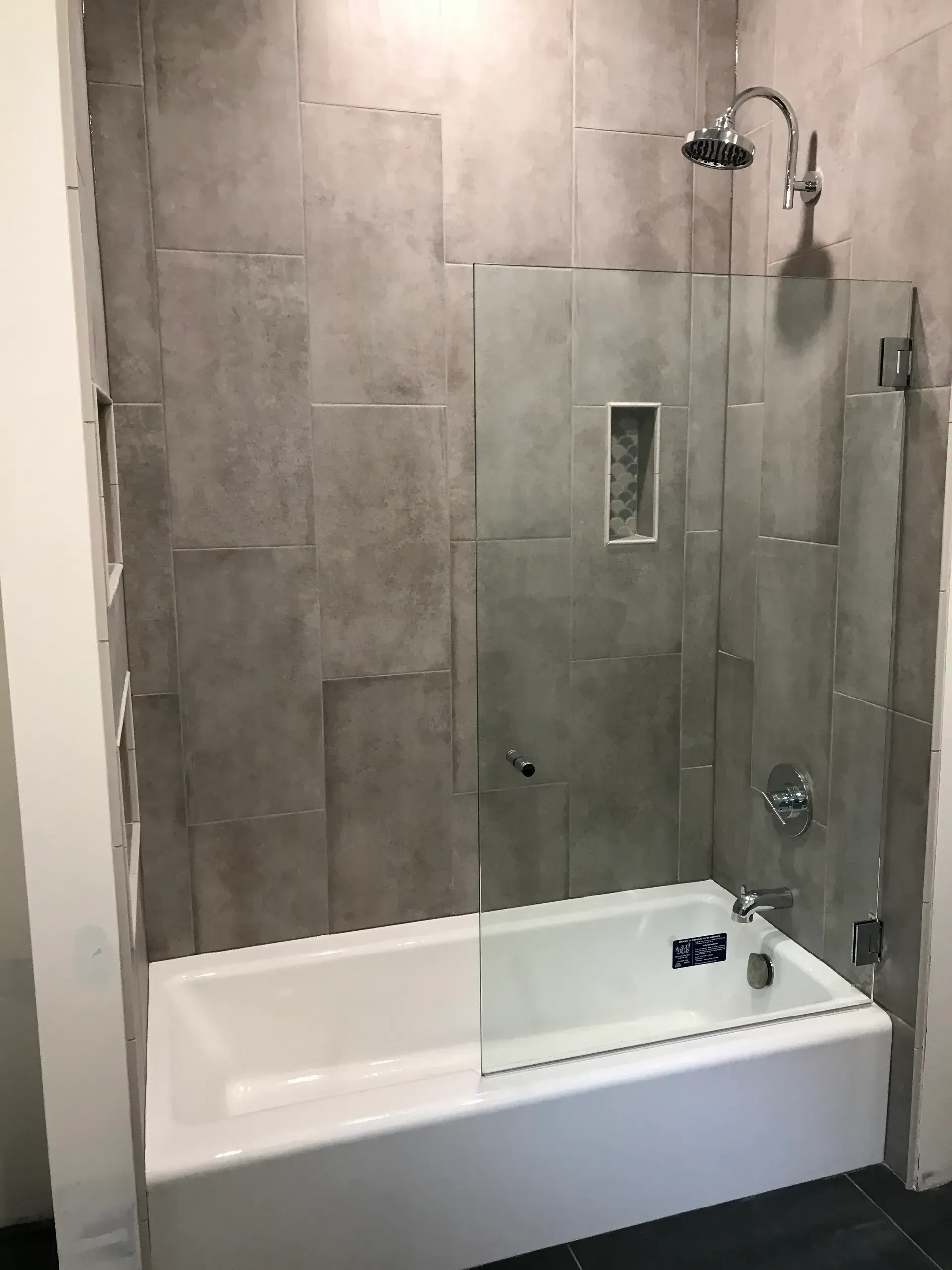 A bathroom with a bathtub and a shower with a glass door.