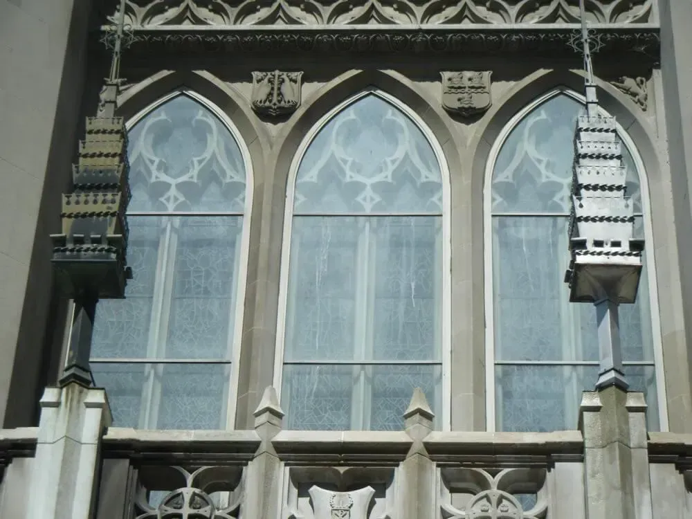 Three arched cathedral windows with intricate tracery and decorative trim.