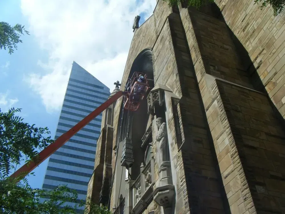Stone church facade with modern skyscraper in background.