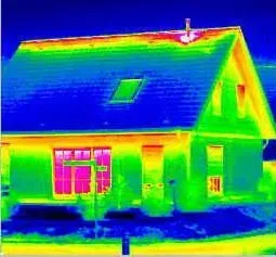 Thermal image of a house; yellow, red, and green where heat escapes, blue roof and walls.