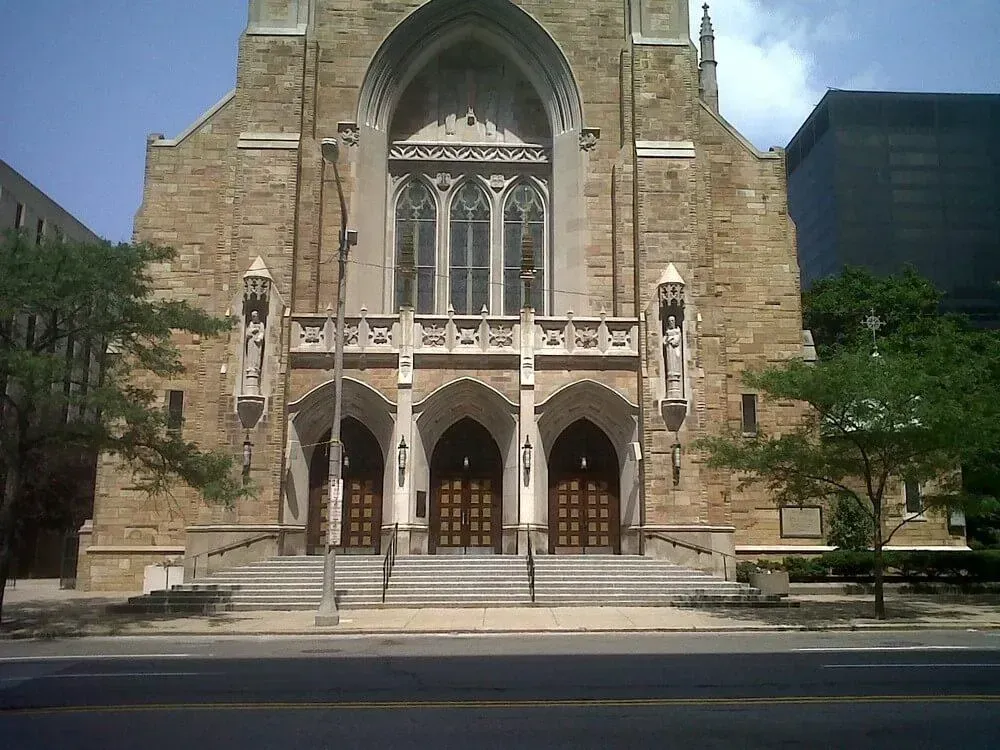 Stone church building with arched entrance and steps.