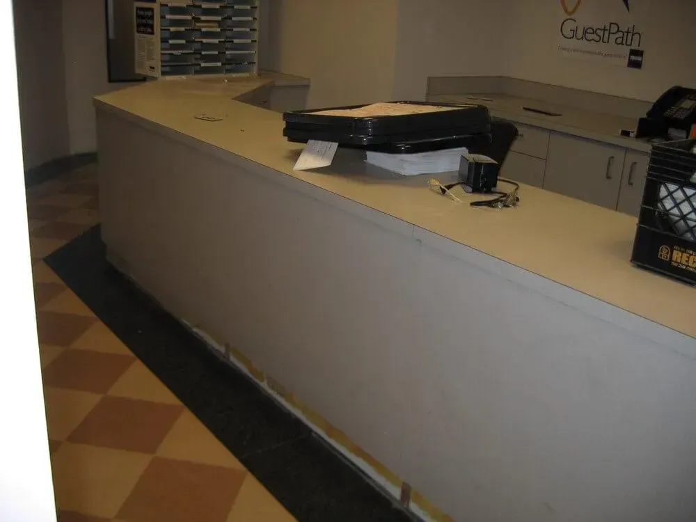 Beige curved reception desk in an office setting.