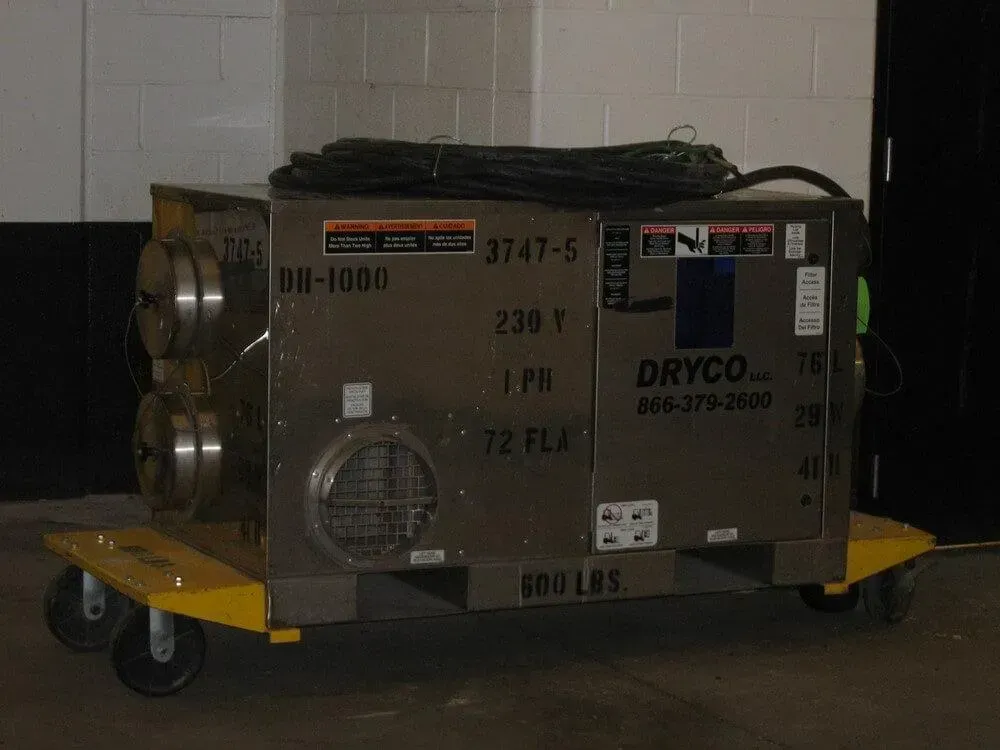 Stainless steel industrial air dryer on a yellow cart.