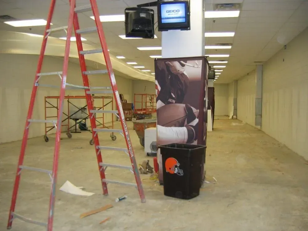 Interior of a store under construction with ladder, scaffolding, and a Browns trash bin.