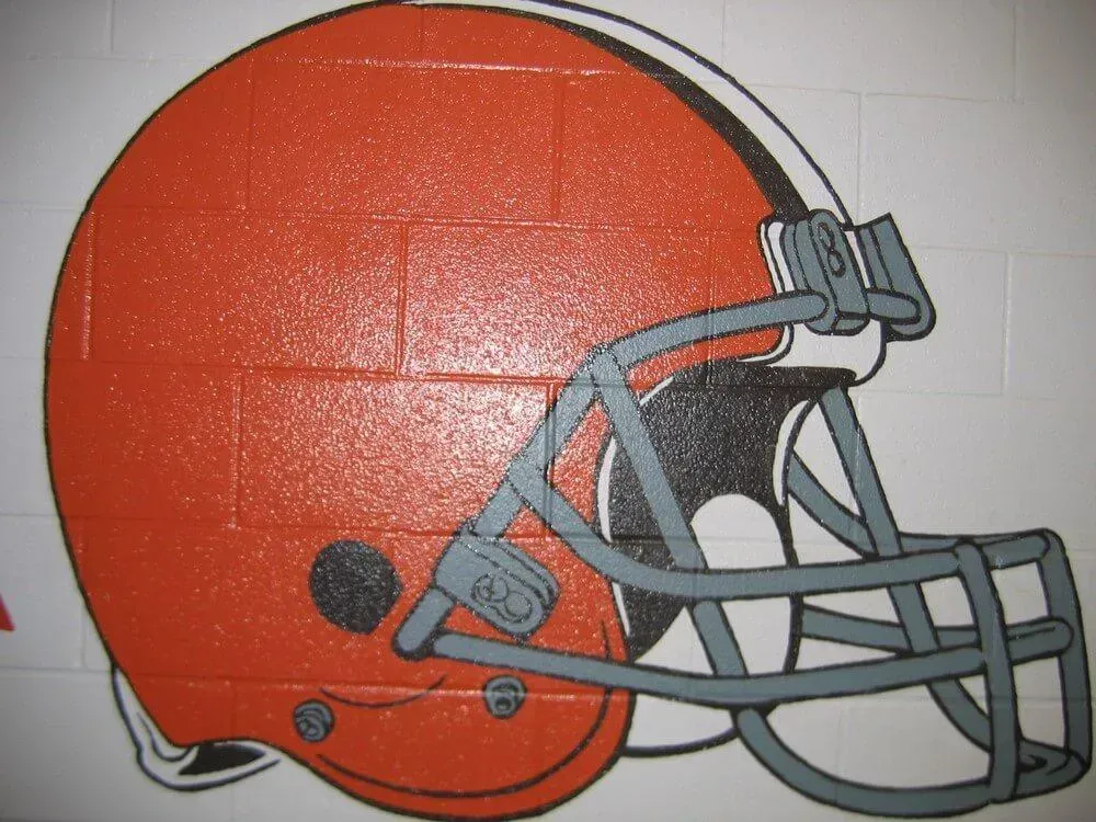Brown Cleveland Browns football helmet painted on a brick wall.