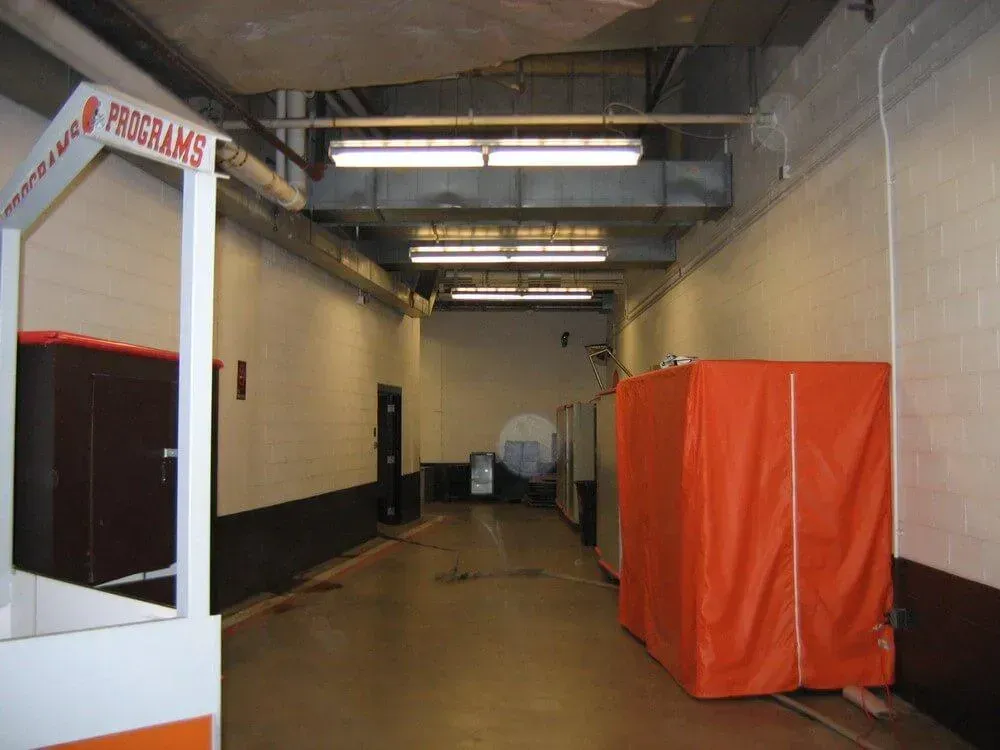 Hallway with orange coverings, fluorescent lights, and a sign that says 