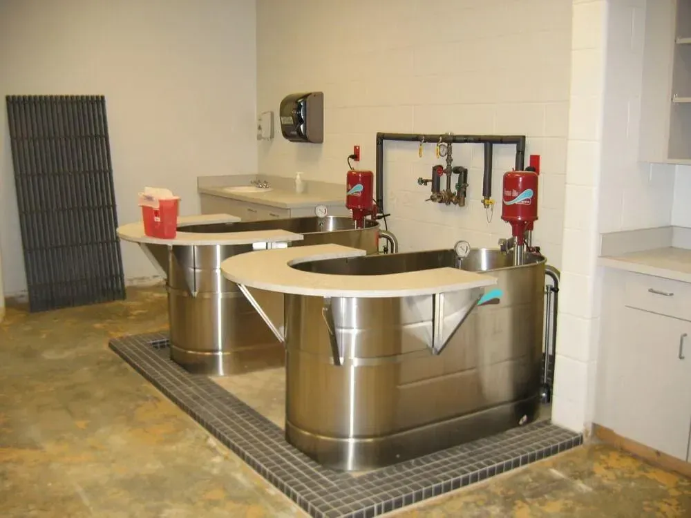 Two stainless steel tanks with work surfaces in a room, likely a lab or processing area.