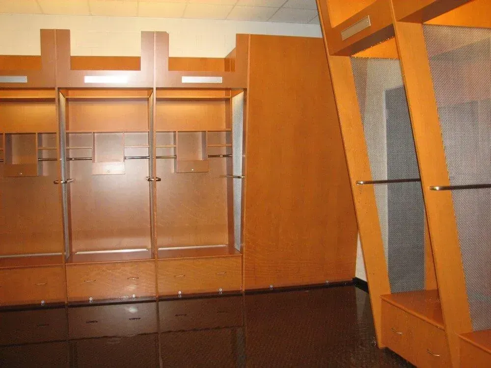 Empty wooden lockers in a well-lit room, possibly a locker room.