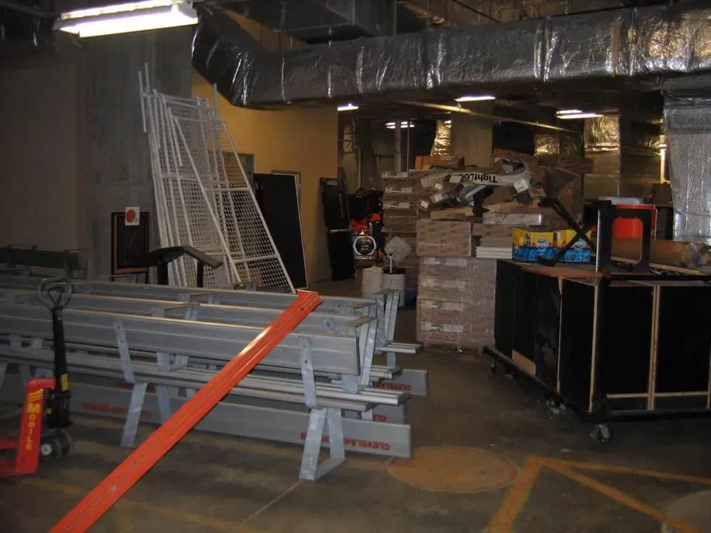 A cluttered storage room with construction materials and equipment.