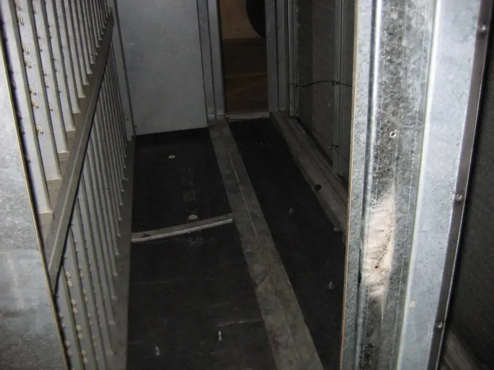 Metal hallway with dark flooring, possibly an elevator.