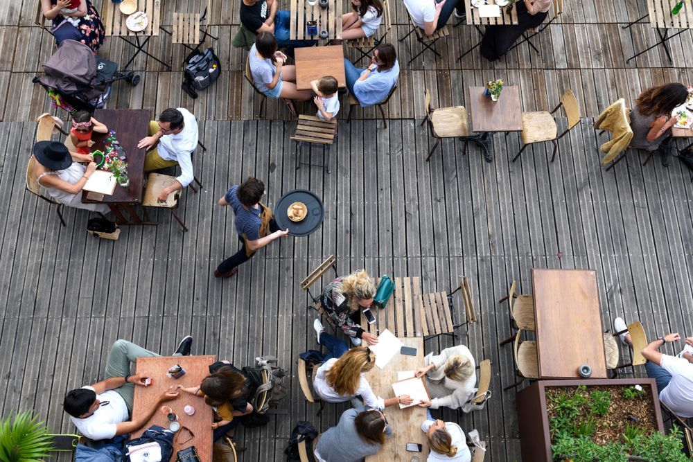 A group of people are sitting at tables in a restaurant.