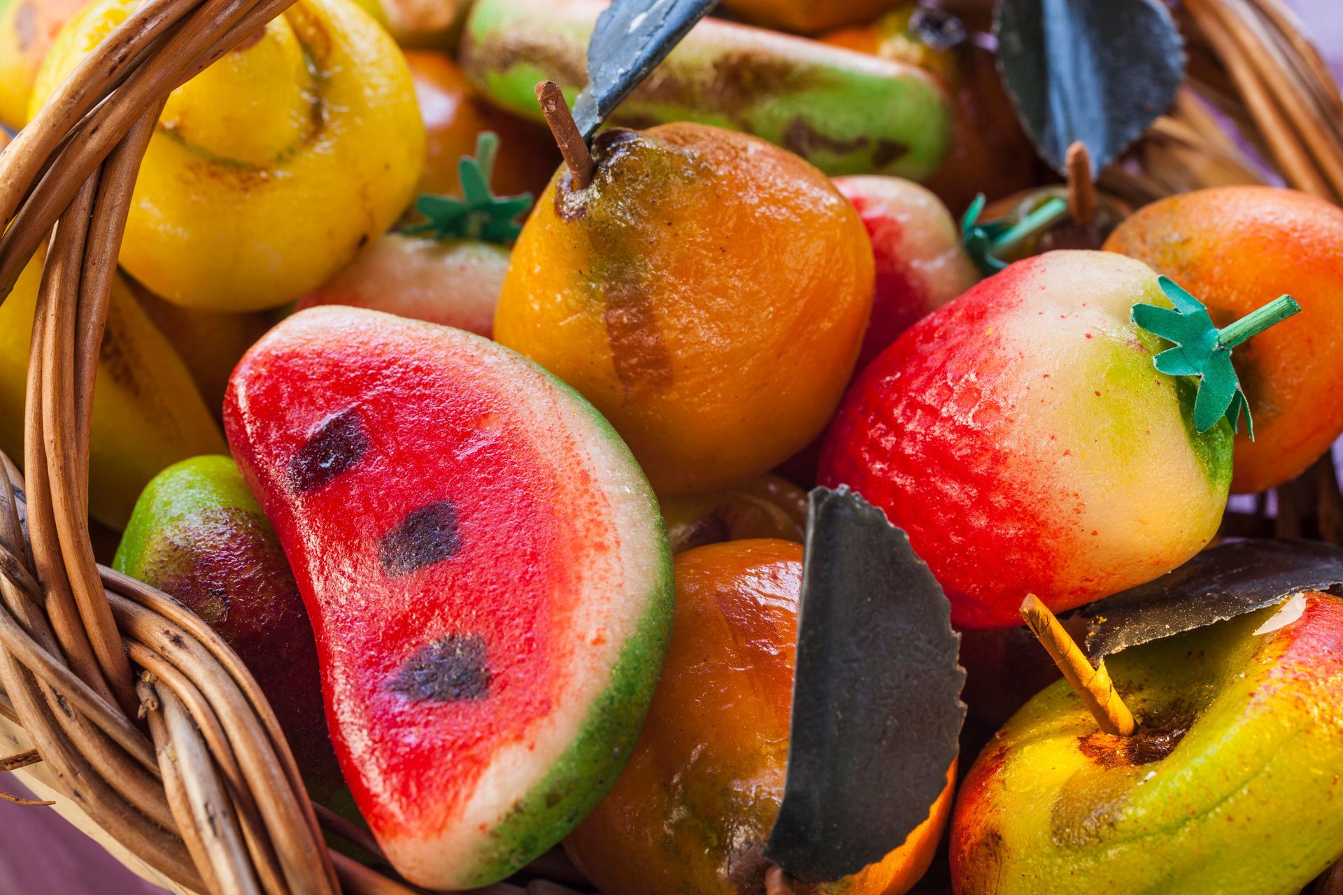 Frutta di marzapane in un cestino di vimini: anguria, pere, fragole, banane.