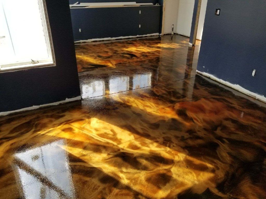 Interior of an empty, well-lit industrial space with a mezzanine and polished gray floor.