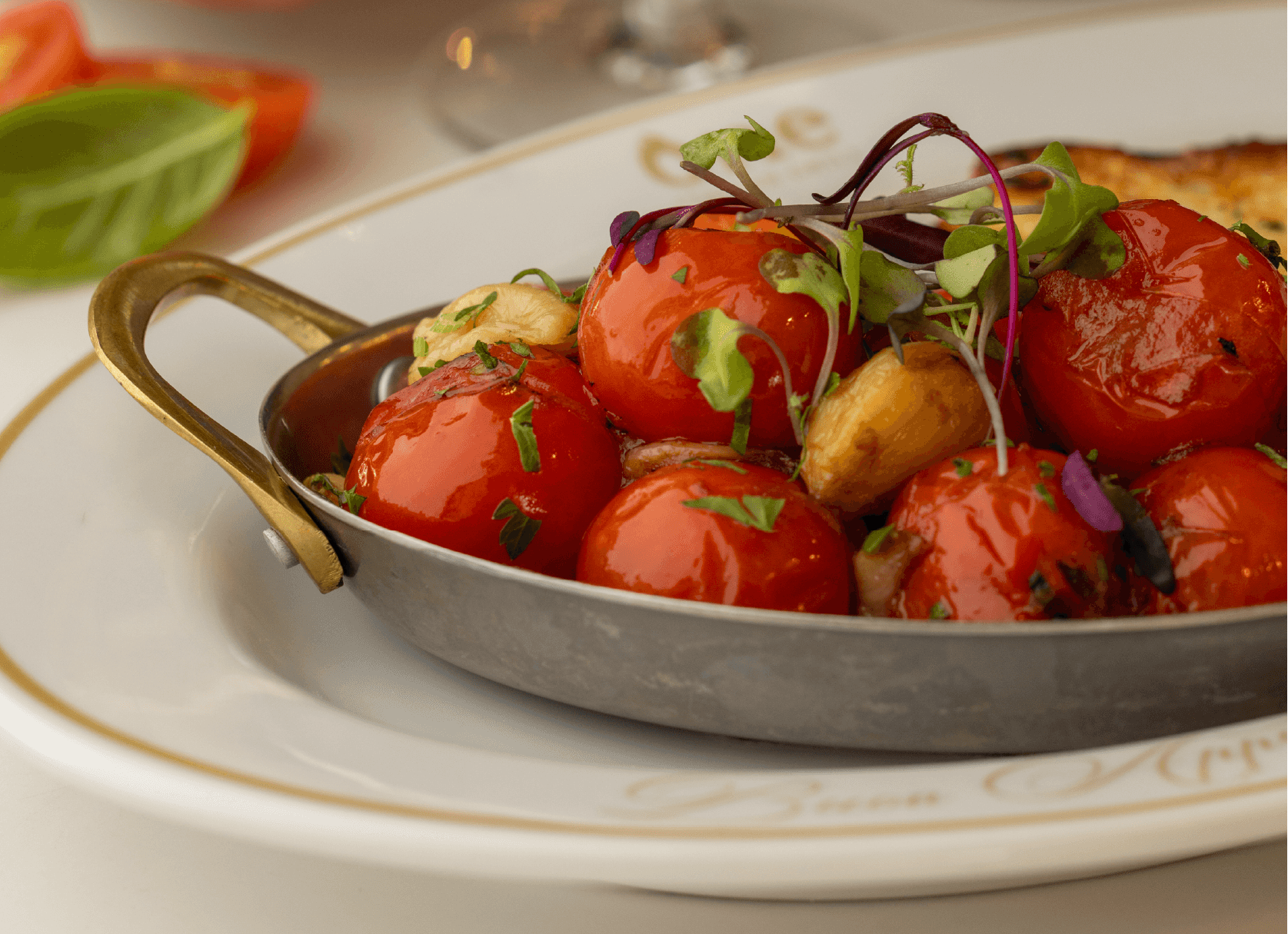 Green and brown olives on a branch with long, green leaves; close-up shot.