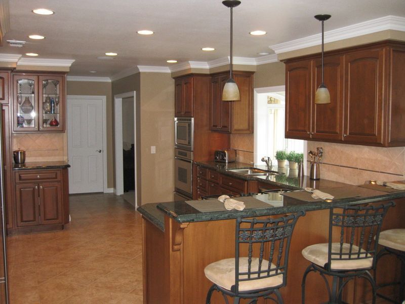 Spacious kitchen with wood cabinets, island seating, stainless appliances, and pendant lighting