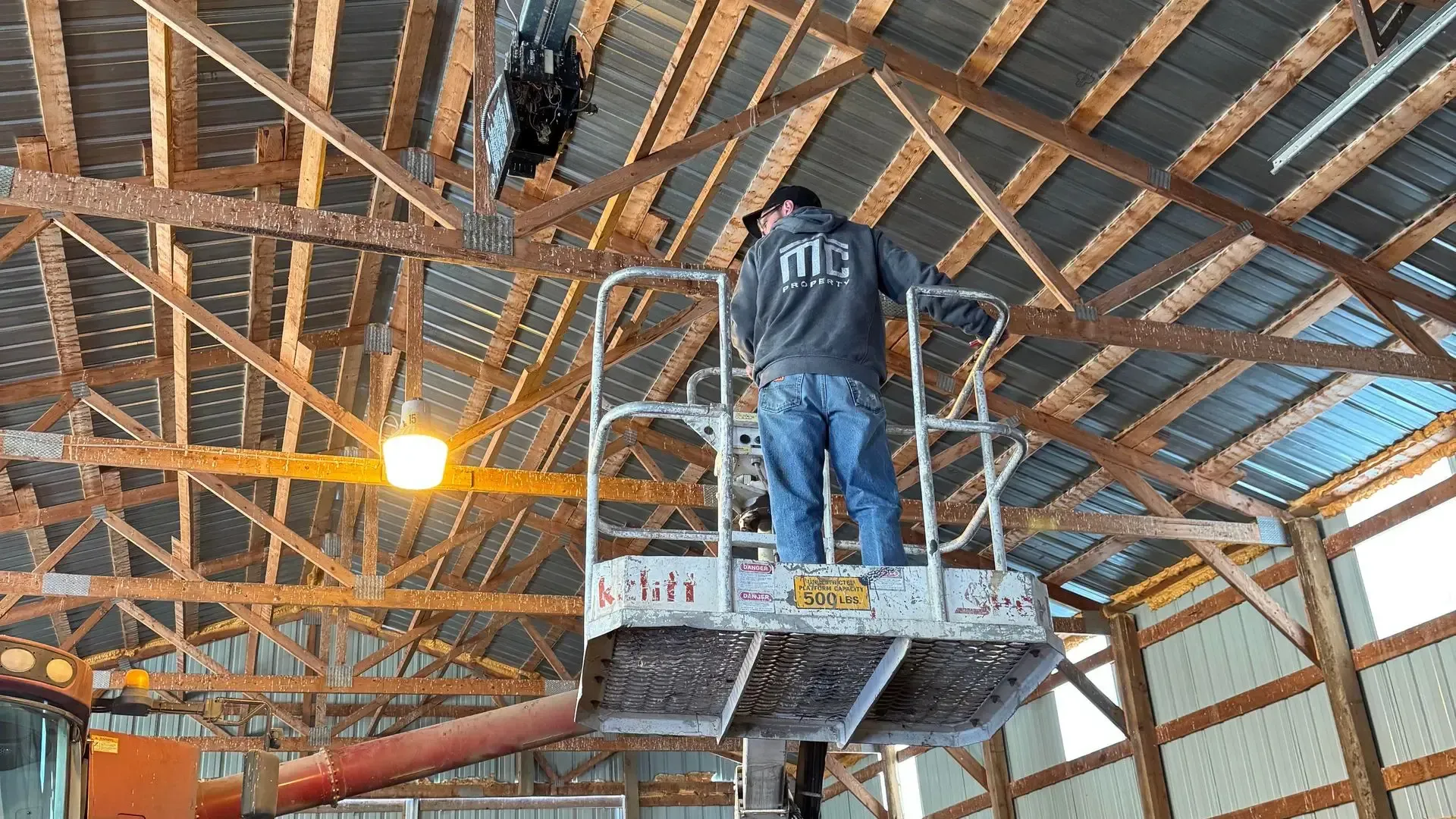 A man is working on the roof of a house with a ladder.