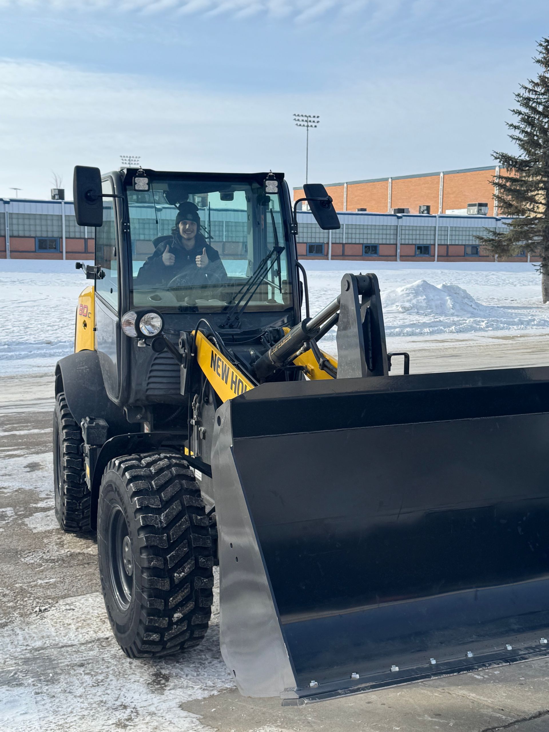 A man is driving a bulldozer in the snow.
