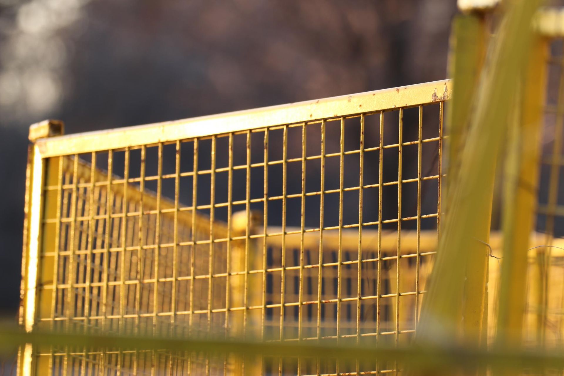 A close up of a metal fence with a blue sky in the background