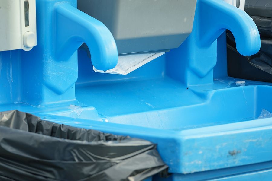 A blue trash can with a black bag in it