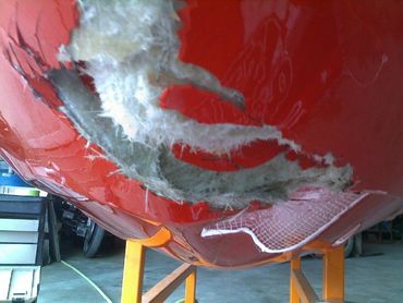 Boat with severe collision damage and exposed fiberglass