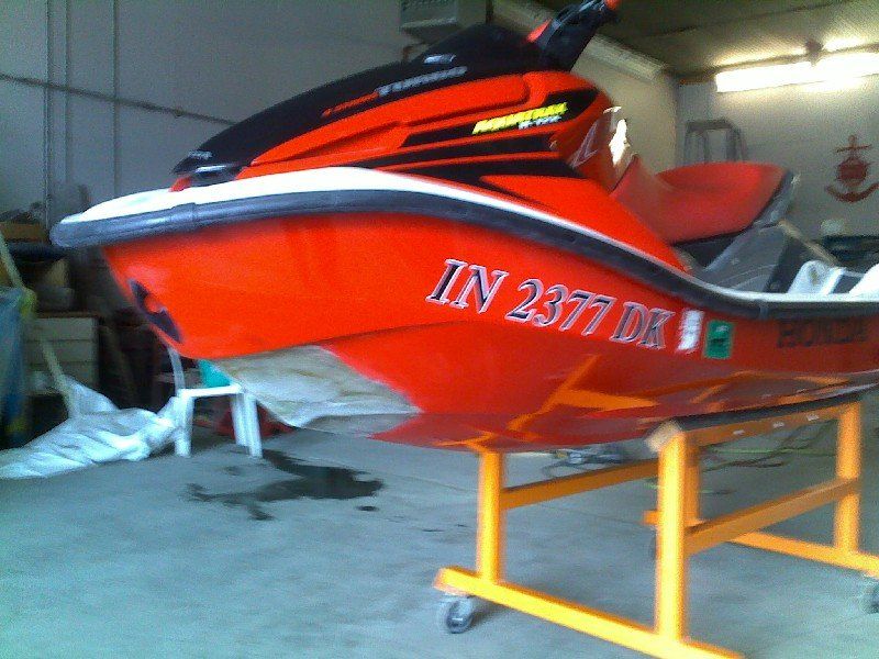 Jet ski with major impact damage and showing exposed fiberglass