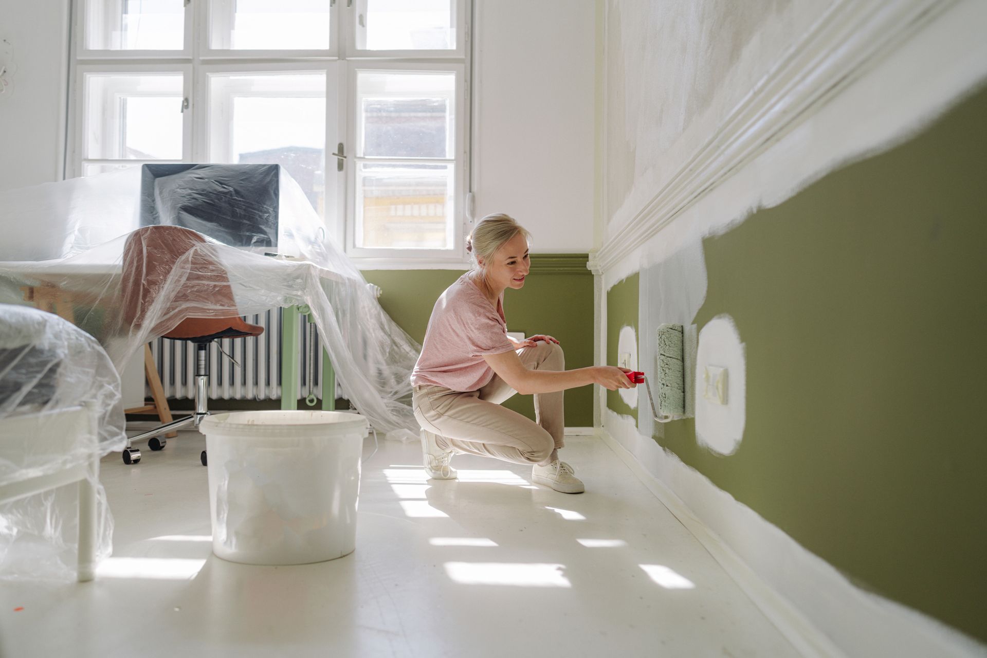 A woman's painting her apartment.