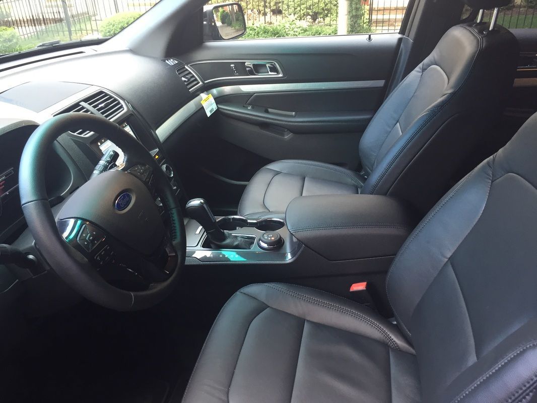Interior view of a black Ford Explorer. Shows the front seats, steering wheel, and dashboard.