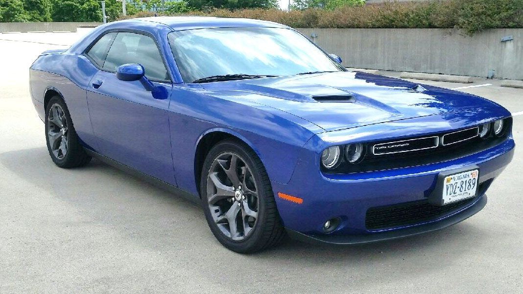 Blue Dodge Challenger parked on pavement.