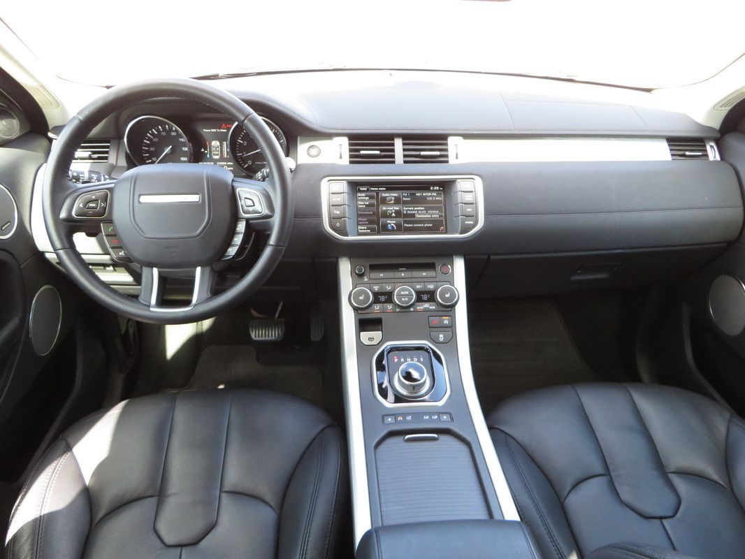 Interior view of a black Range Rover dashboard with leather seats and a center console.