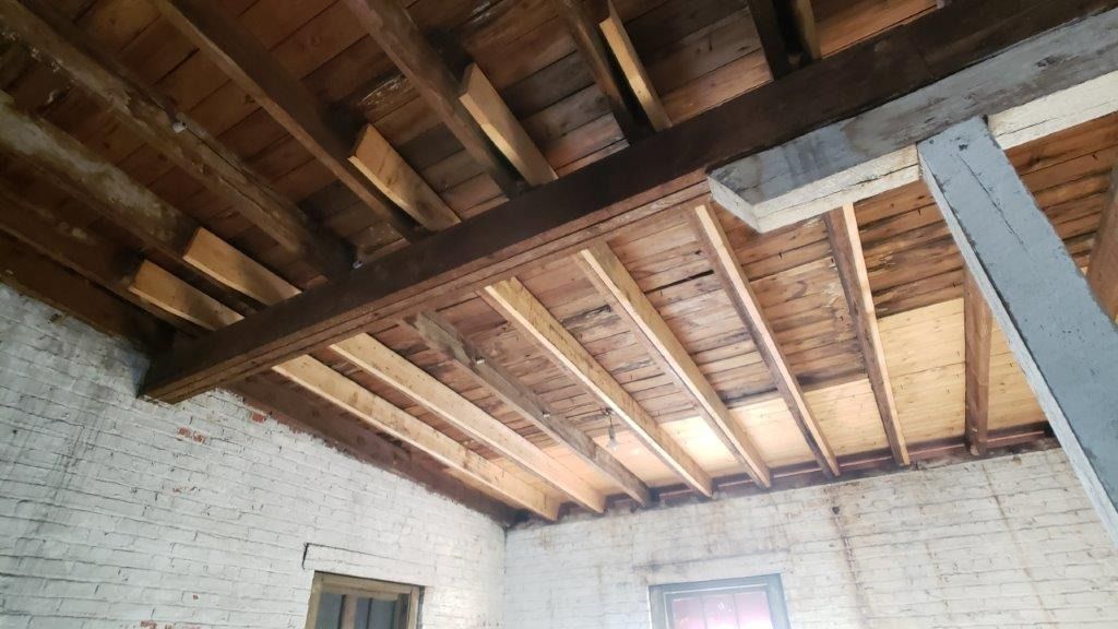 A room with a wooden ceiling and white brick walls.
