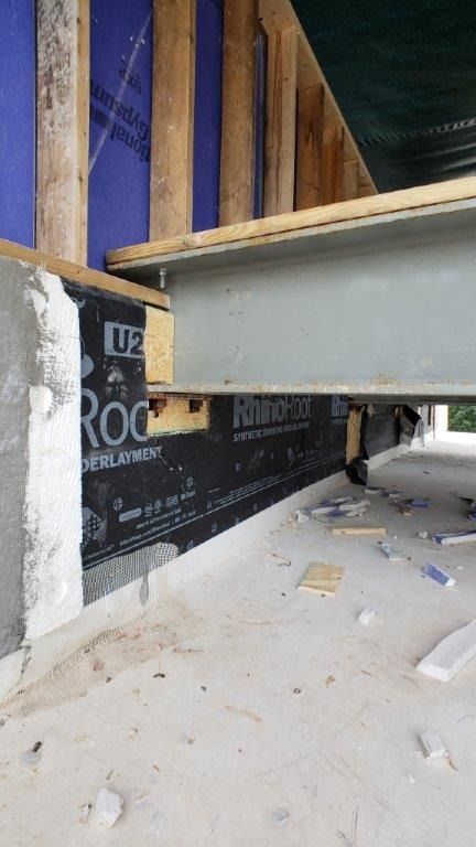 A metal beam is being installed in a building under construction.