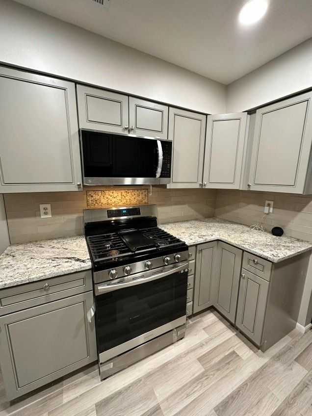 A kitchen with stainless steel appliances and granite counter tops.