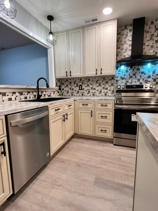 A kitchen with white cabinets and stainless steel appliances.