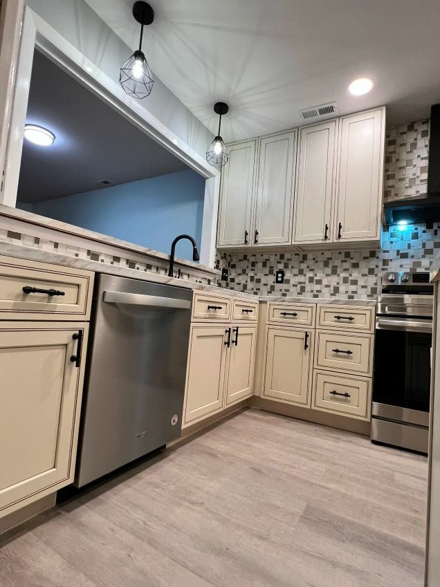 A kitchen with white cabinets and stainless steel appliances.