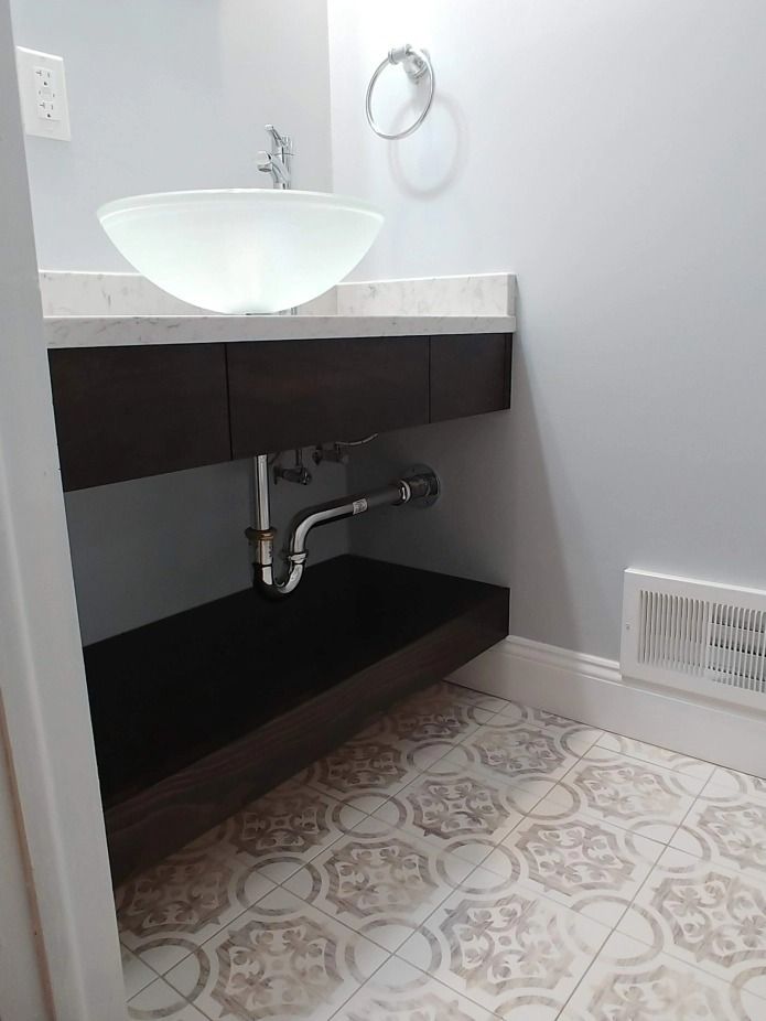 A bathroom with a sink and a tiled floor.