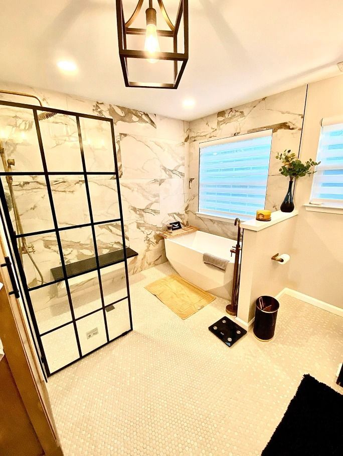 A bathroom with a tub , shower , and window.
