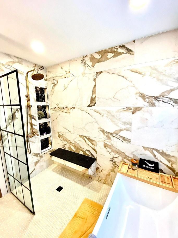 A bathroom with marble tiles and a walk in shower.