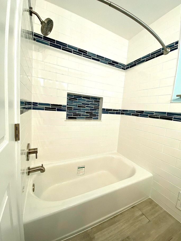 A bathroom with a bathtub and a shower.